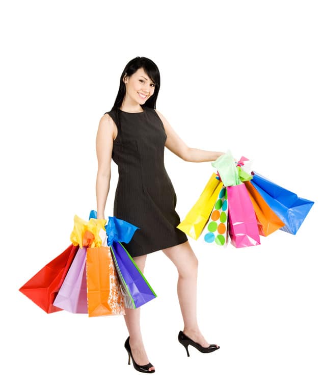 An isolated shot of a beautiful woman carrying shopping bags